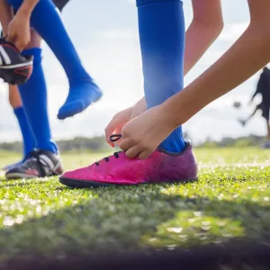 Boy tying soccer shoe